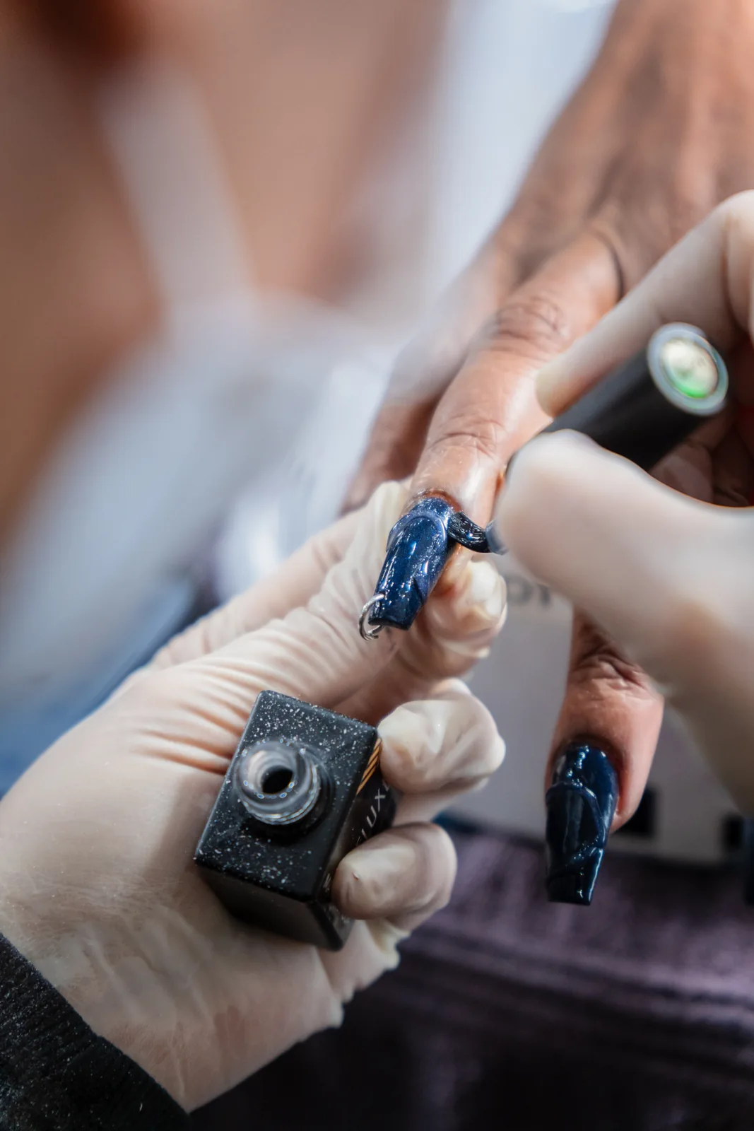 Close-up of blue reflective nails during a salon service